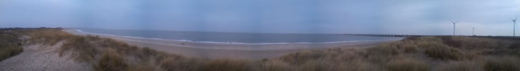 Panorama des Banjaardstrand mit Dünen und Windrädern