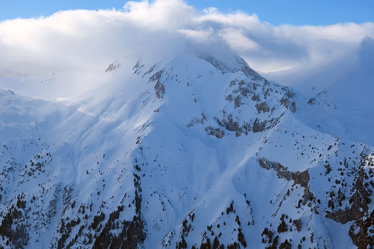 Sneeuwbedekte rotsachtige bergtoppen onder wolken