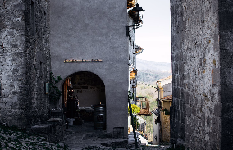 Steingasse in Hum mit Torbogen einer Bar