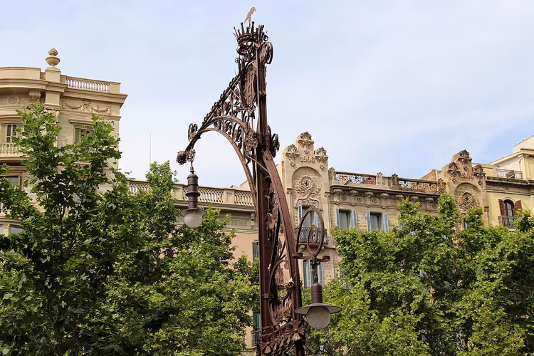 Dekorativ gatelykt mot fasader i Barcelona