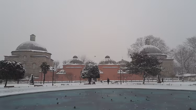 Snødekt Hürrem Sultan-hammam med kupler og en fontene