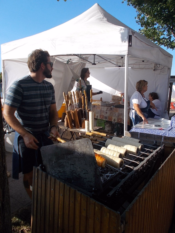 Kürtőskalács em espetos sobre brasas numa barraca de rua