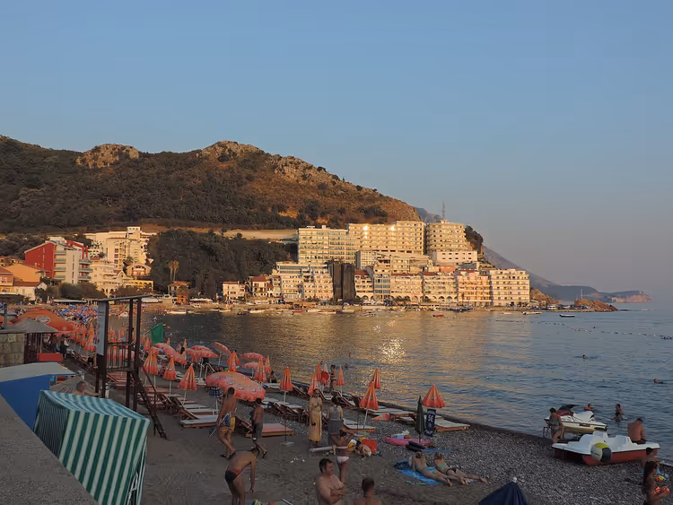 Bečići strand met parasols en een hotel aan zee