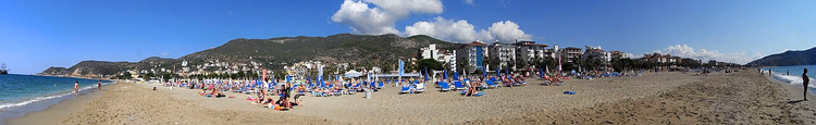 Şezlonglar ve otellerle Alanya kum plajı
