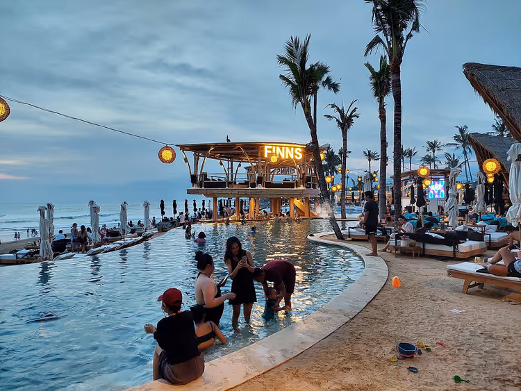 Zwembad van Finns Beach Club in Canggu bij zonsondergang