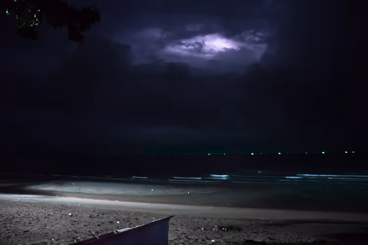 Nachtstrand met een onweersbui en bliksem boven de zee