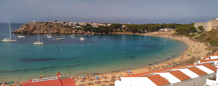 Arenal d'en Castell-strand met boten en hotels