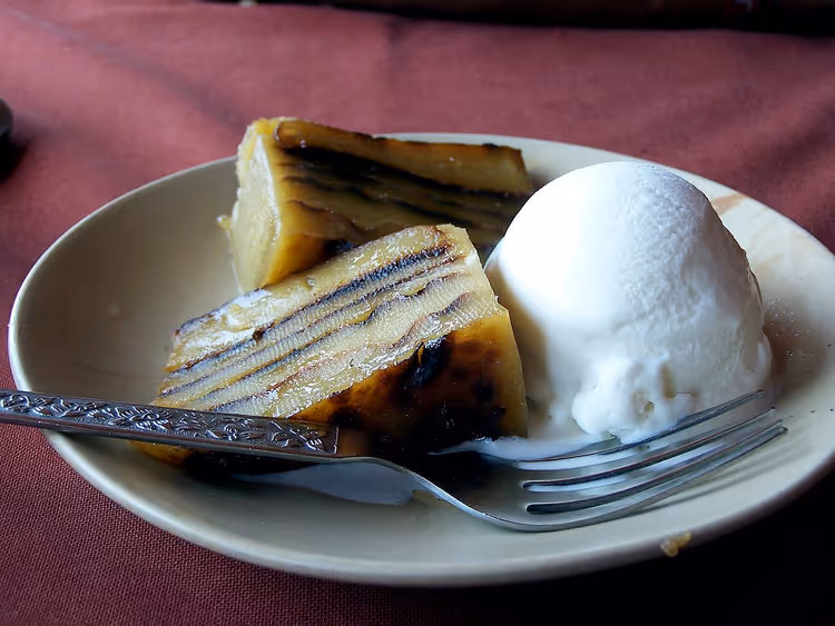 Bebinca-Stücke mit einer Kugel Eis auf einem Teller