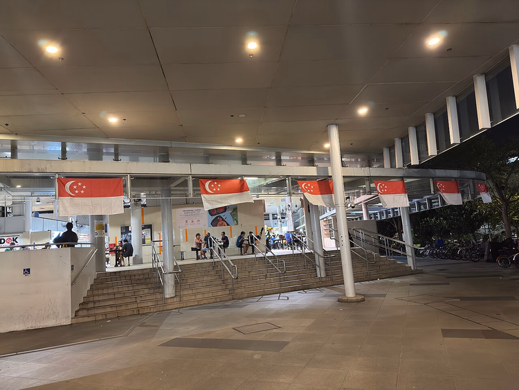 Eingang des Bedok Hawker Centre mit Singapur-Flaggen