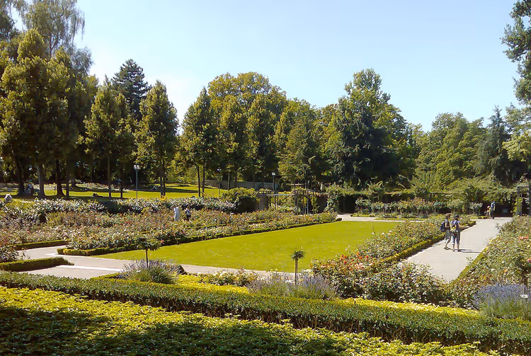 Park med plen, blomsterbed og stier
