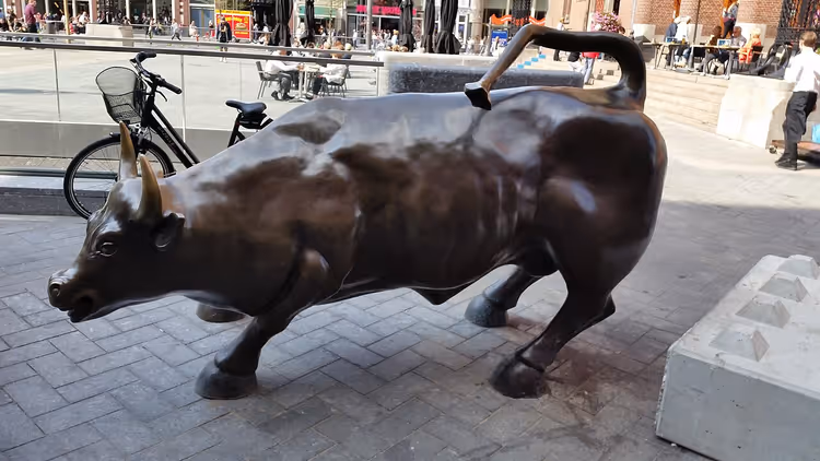 Bronzen beeld van een stier op een met kinderkopjes geplaveid stadsplein