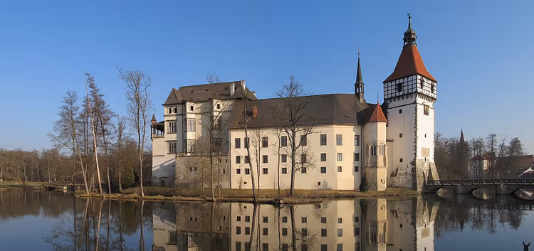 Schloss Blatná mit Turm und Spiegelung im Wasser