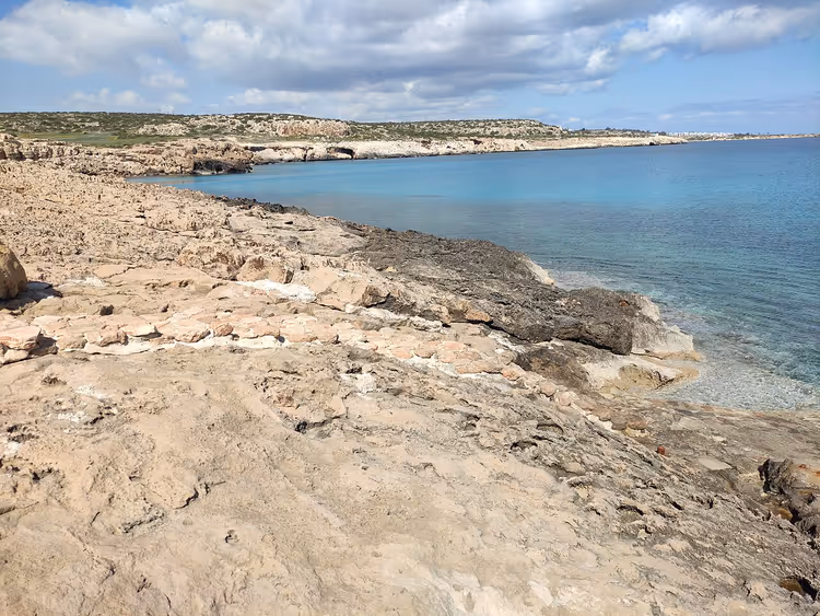 Turquoise water bij de rotsachtige kust van Cape Greco