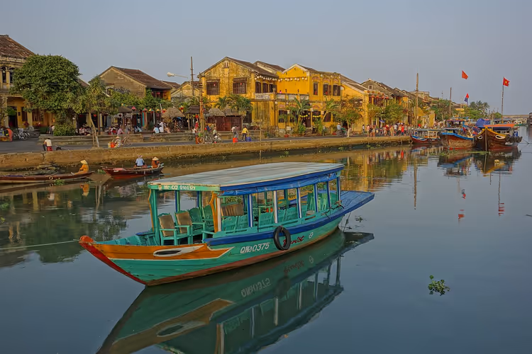 Boot an der Uferpromenade von Hoi An mit gelben Häusern