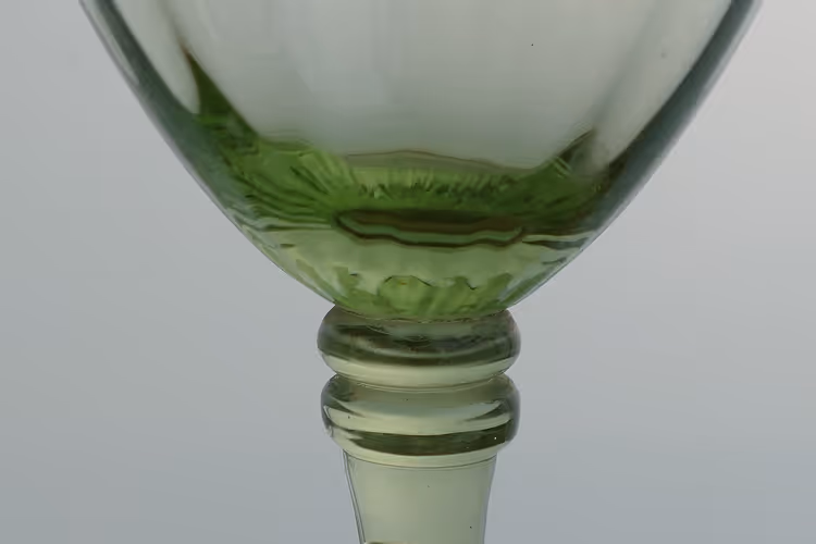 Detail van een groen Boheems glas met geslepen steel
