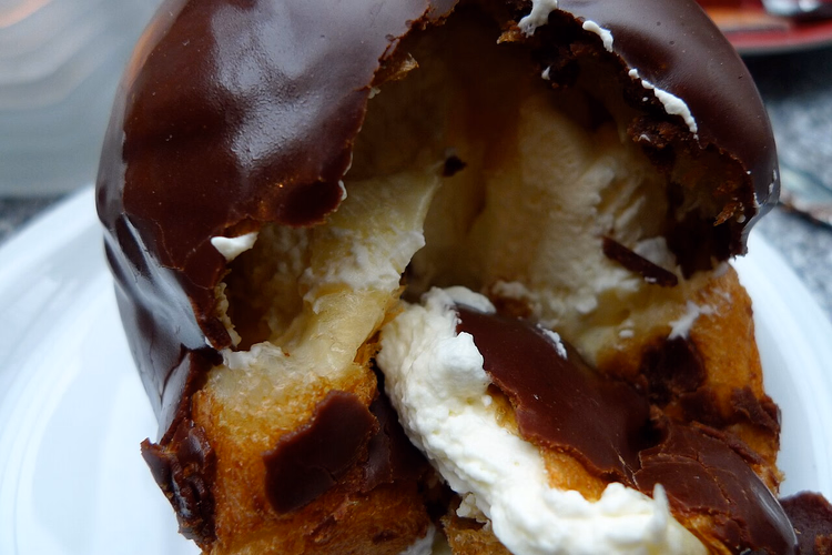 Aufgeschnittene Bossche Bol mit Schlagsahnefüllung