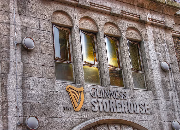 Fasaden til Guinness Storehouse med skilt og harpe