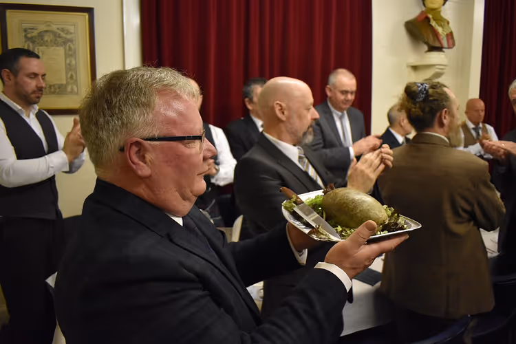 Bir ziyafette elinde tabak dolusu haggis tutan adam