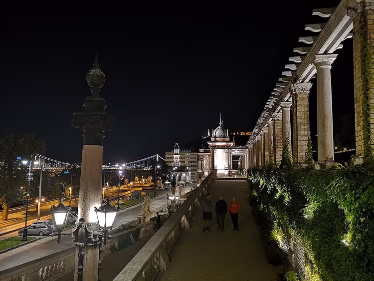 Nachtelijke colonnade van Várkert Bazár met wandelende mensen