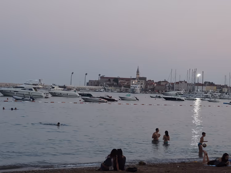 خليج بودفا مساءً مع القوارب وبرج كنيسة