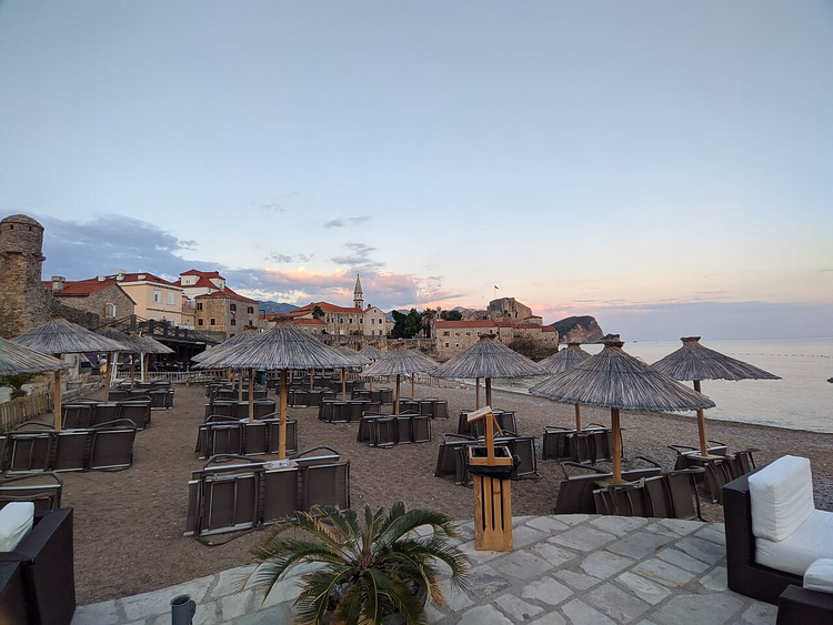 Strand met parasols bij de muren van Oud-Budva