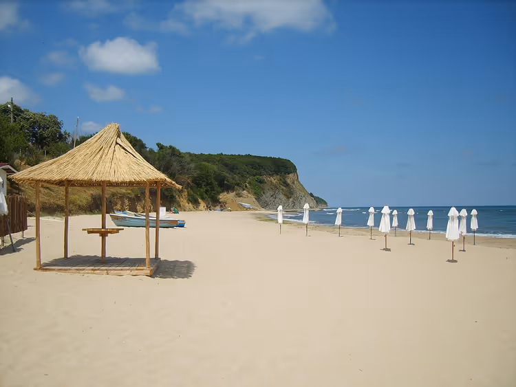 Spiaggia di Irakli con una tettoia di paglia e ombrelloni