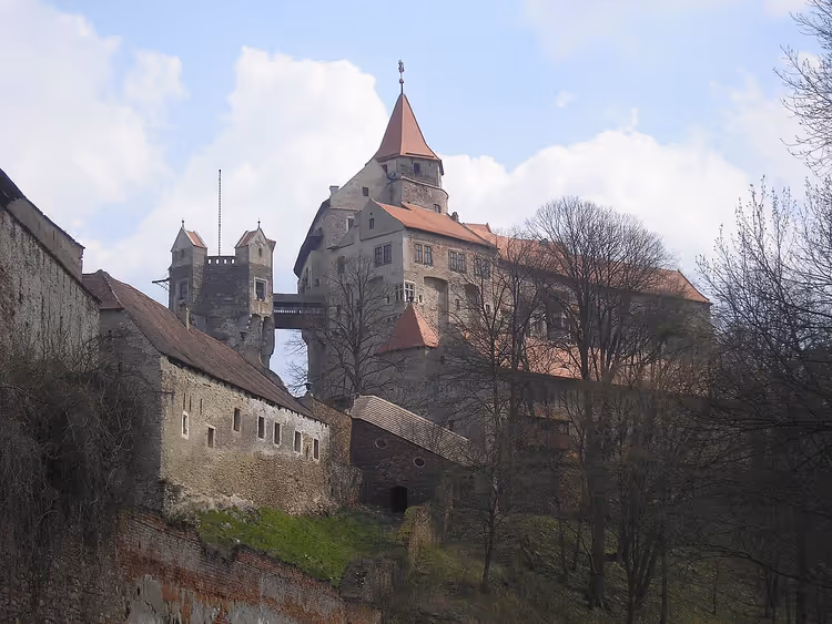 Burg Pernštejn auf einem Hügel zwischen Bäumen