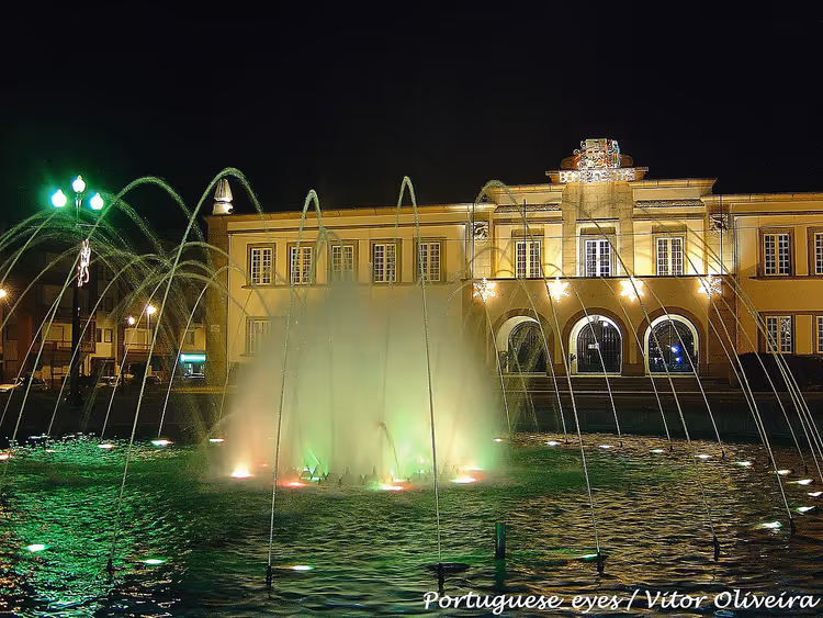 Stadhuis van Espinho bij nacht met een fontein en verlichting