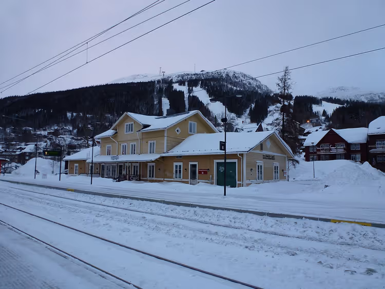 Snødekt Ore stasjon med fjell og spor