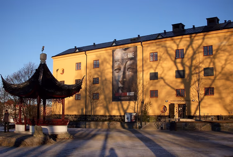 Geel museumgebouw met een banier en Chinees paviljoen