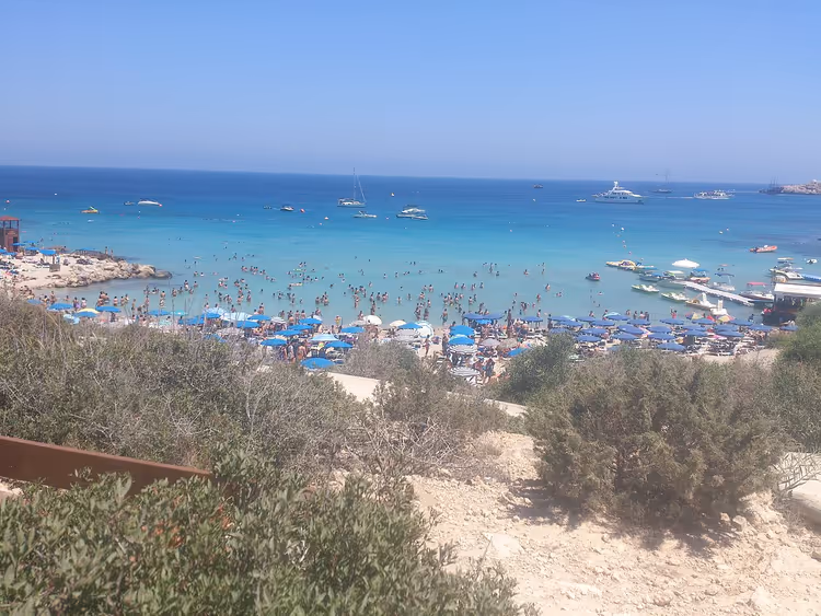 الناس على الشاطئ والقوارب في خليج كونوس