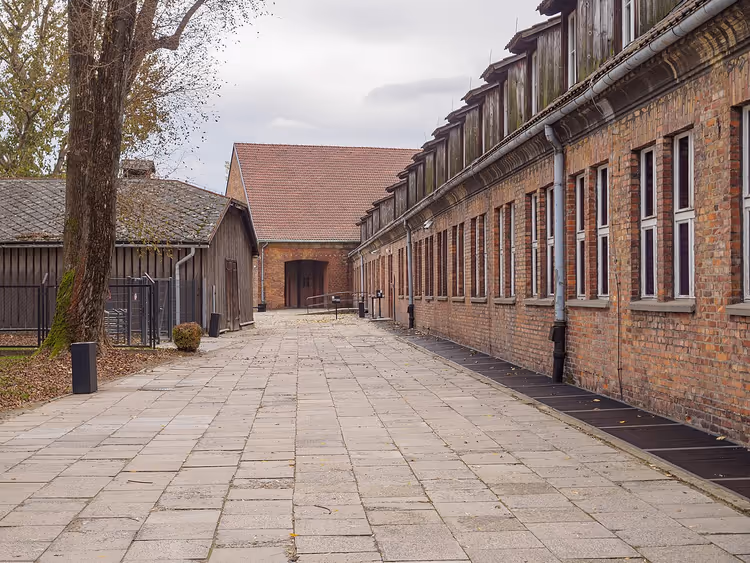Bakstenen barakken van het Museum Auschwitz-Birkenau langs een pad