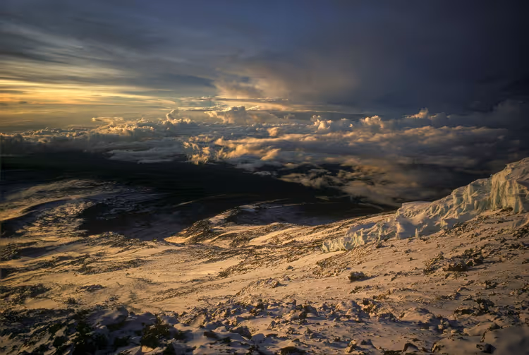 Besneeuwd Kibo-plateau met ijsrotsen boven de wolken