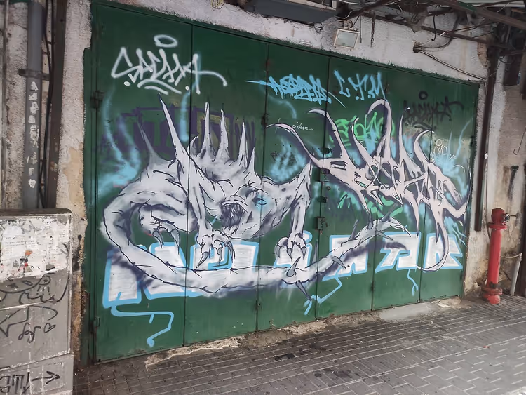 بوابة خضراء عليها رسم جرافيتي لوحش
