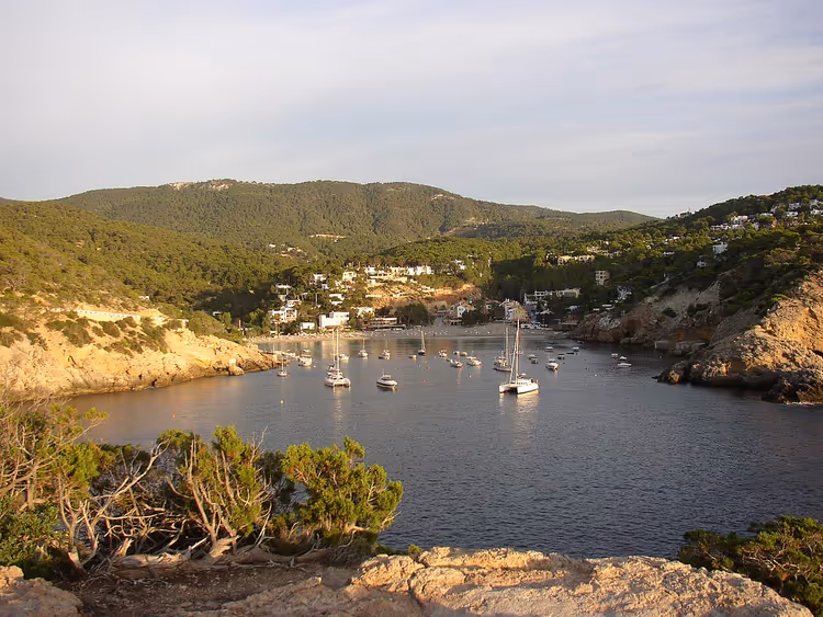 Tekneler ve tepelerle Cala Vadella koyu