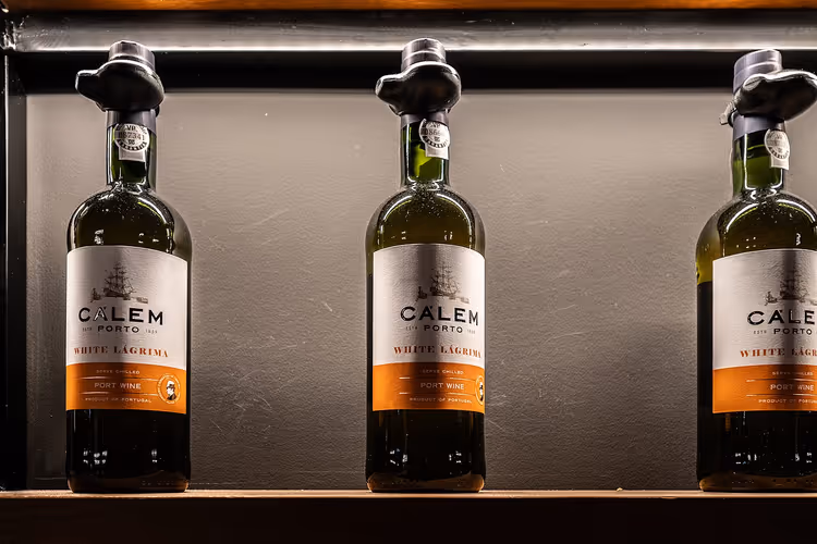 Drei Flaschen Calem White Lágrima Portwein in einem Regal