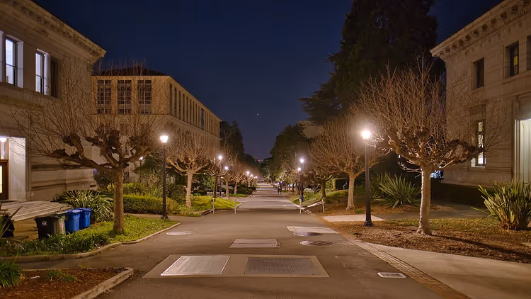 Pad op de Berkeley-campus bij nacht met lantaarns en bomen
