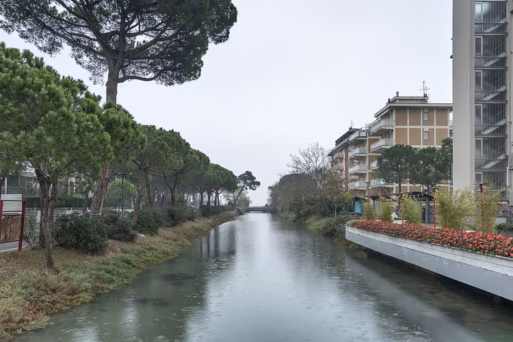 Kanal med furutrær og blomster i Milano Marittima
