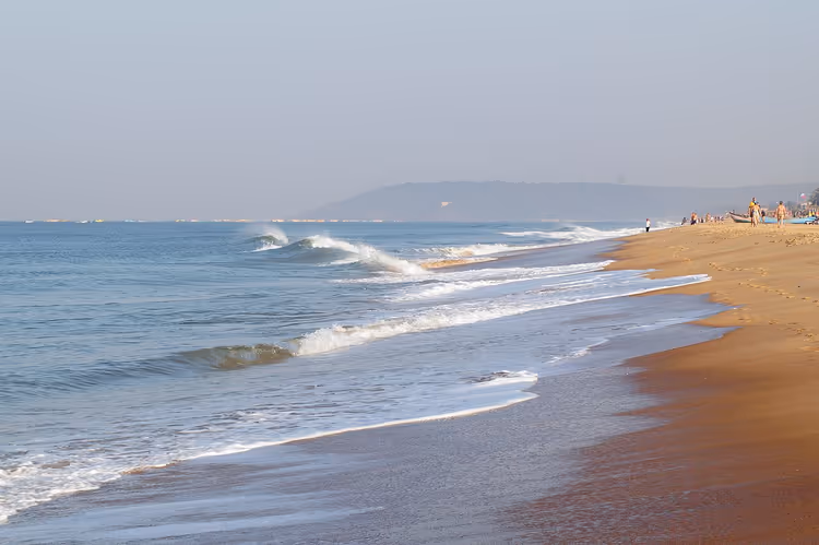Candolim Beach met branding en een landtong in de verte