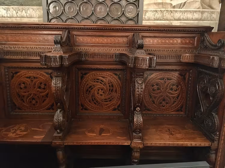 Gesneden houten banken met inlegwerk in de kapel