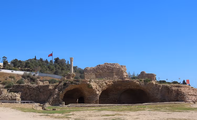Oude ruïnes van Carthago met bogen en de vlag van Tunesië