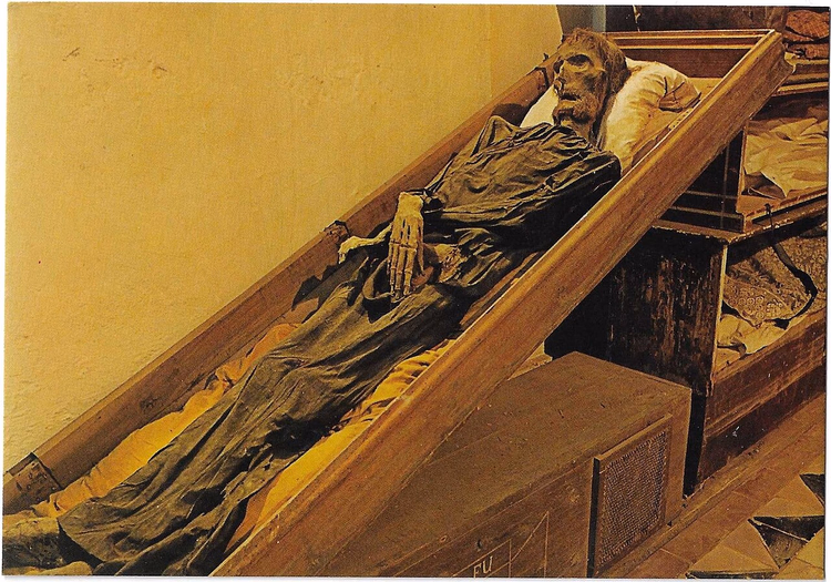 Mummie in een scheefstaande kist in de catacomben