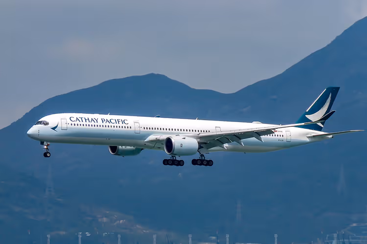 Cathay Pacific-fly med landingshjulene nede over fjellene