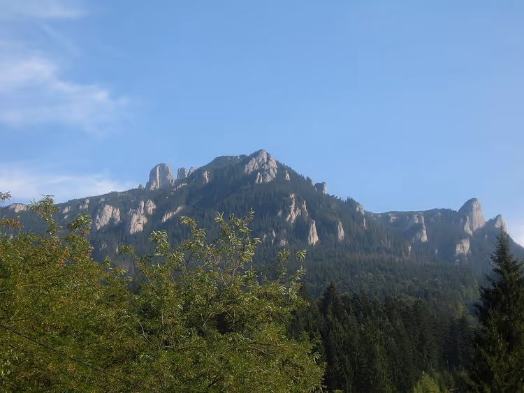 Klippefulle Ceahlău-topper over skogkledde skråninger