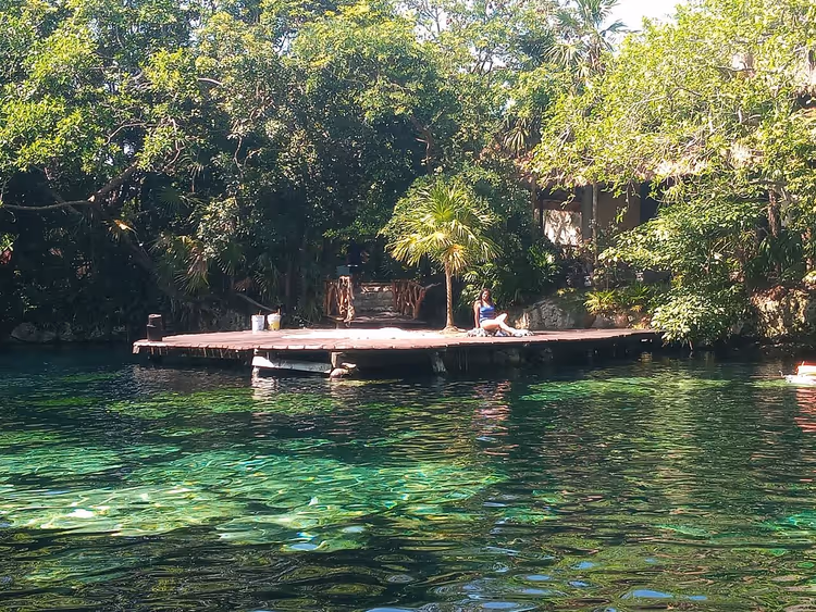 Cenote met houten deck in de jungle bij Sandos Caracol Hotel