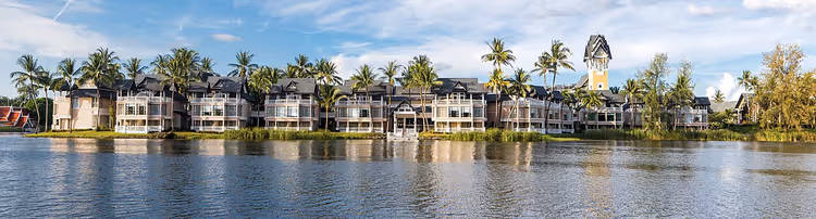 Вид на Cassia Phuket через водоём с пальмами