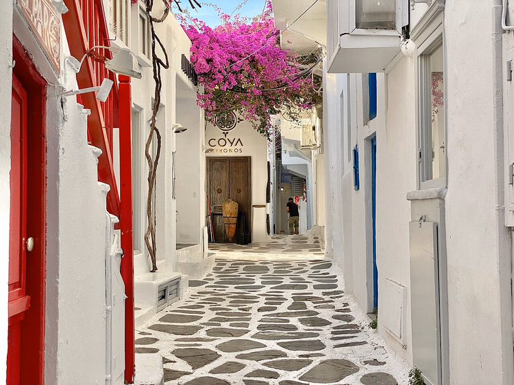 Un callejón blanco en Chora, Miconos, con buganvillas