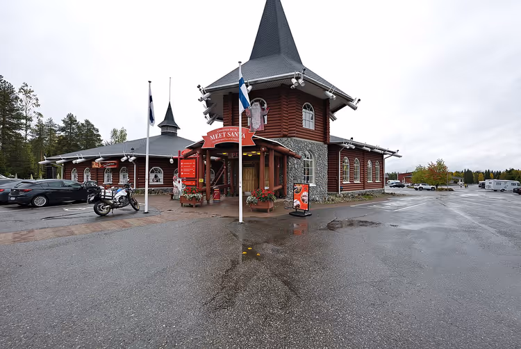 Красное здание Santa Claus Village с башней в Рованиеми