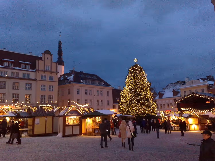 Kerstmarkt op een besneeuwd plein met een grote kerstboom