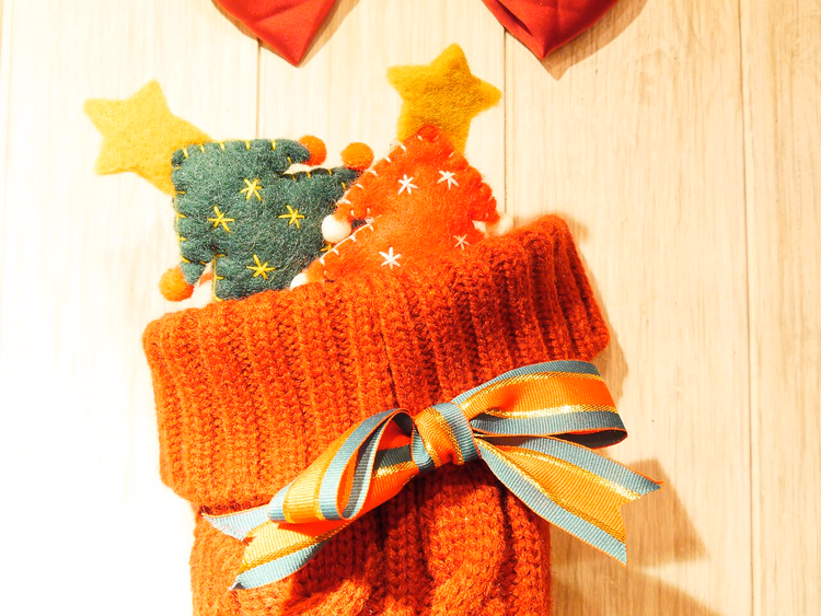 Gebreide kerstkous met een strik en speelgoed